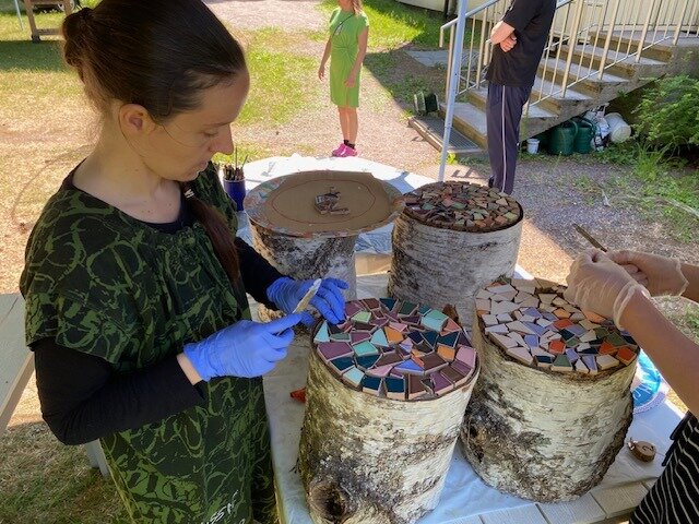 Mosaiikkipalojen kiinnitystä liimaten.