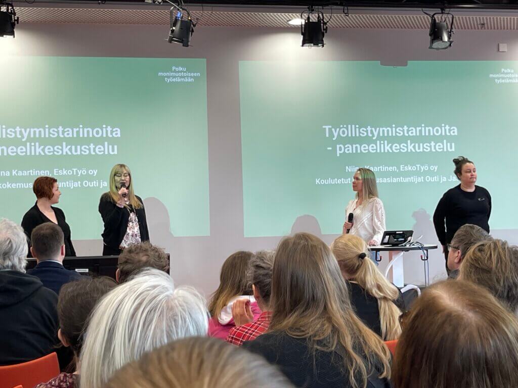 Työllistymistarinoita -paneelikeskustelun osallistujia ja kuuntelijoita.