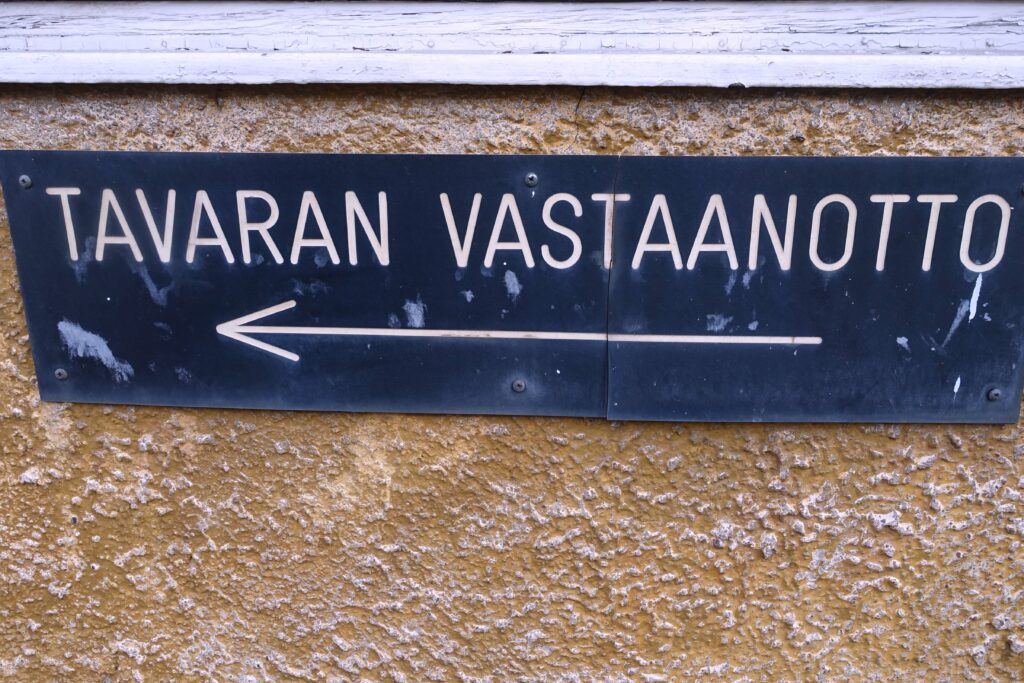 Kyltti, jossa lukee "Tavaran vastaanotto" ja nuoli vasemmalle.